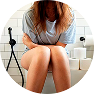 mulher sentada numa sanita em visiviel desconforto